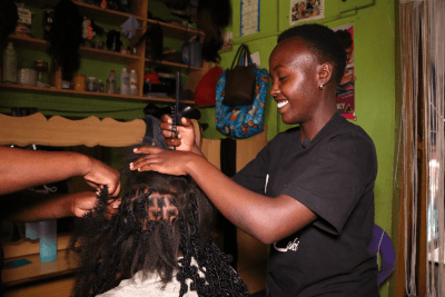 Miriam Wanjiku dressing a client's hair